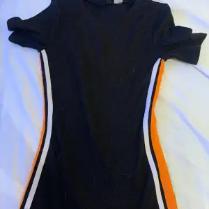 Svart kläning med vit orange linje på sidorna knappt använd 