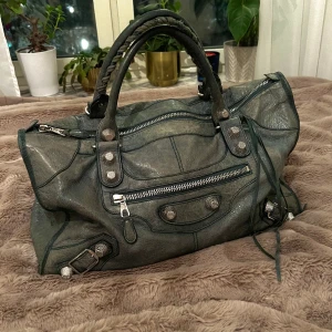 Balenciaga väska - Gör en intressekoll på min grå/gröna balenciaga väska som är köpt på vestiare! Skyddspåse ingår💛 Skriv till mig privat vid frågor! 