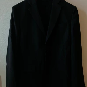 Svart Kavaj - Svart Kavaj i storlek 46 (S) ifrån J.Lindeberg. Iprincip ny den är använd 2 gånger. Otroligt bra kavaj som går med både kostymbyxor eller jeans.