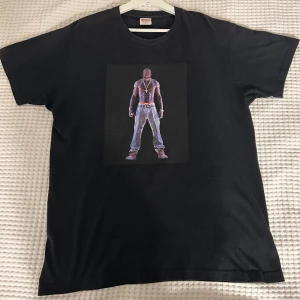 Supreme Tupac Hologram Tee - Utmärkt skick på T shirten! Har använt den ett par gånger, men passar inte riktigt min stil. Den har något oversize passform. Mer information eller bilder vid behov. Om du inte är nöjd med priset, skicka gärna ett dm, så kan vi diskutera det. 