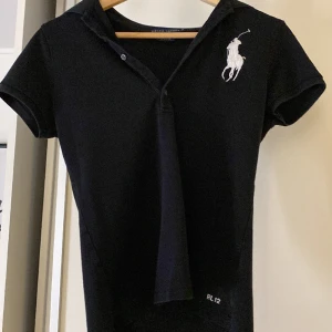 Ralph lauren t-shirt - Svart Ralph lauren t-shirt i storlek M med krage. Skulle säga att den nog passar bra på dom med storlek S🖤