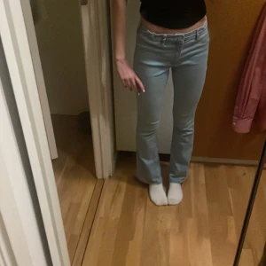 Blåa bootcut jeans - Säljer ett par fina ljusblåa lågmidjade bootcut jeans ifrån H&M 