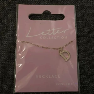 Halsband  - Halsband med bokstaven D.  Oanvänd.