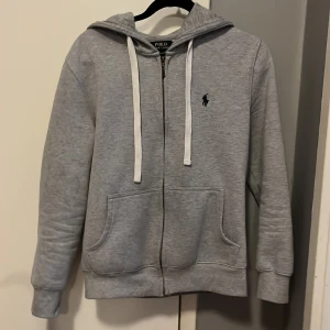 Polo Ralph Lauren hoodie  - Jag säljer min grå zip hoodie ifrån polo Ralph Lauren. Den är i väldigt bra skick (9/10) med få till obefintliga defekter. Nypris 2095:- Mitt pris 650:- går att diskutera