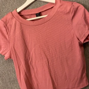 Gammelrosa T-shirt  - Varan är i bra skick men den ser missfärgad ut men det är den inte, ljuset är dåligt så kan ta mer bilder vid intresse.