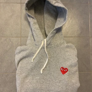 Comme Des Garcons hoodie S - Grå CDG hoodie. Bra skick men väl använd, 6/7 av 10.  Inga skador eller fläckar. Storlek Small men skulle säga att den är lite liten i passformen, har du storlek XS eller ligger mellan XS och S så är denna hoodie perfekt. Köpt ny för ca 2500kr på NK