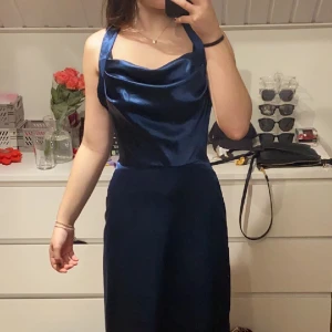 Balklänning  - En jätte fin mörkblå bal liknande klänning i satin som är öppen i ryggen 