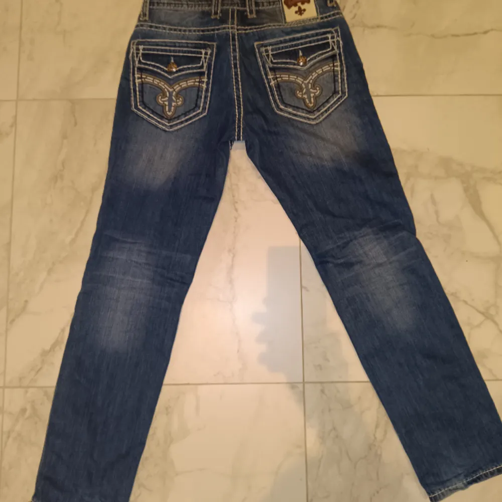 Tvärfeta Rock Revival Jeans size 32/33 straight fit fat stich bra skick, skriv om du har frågor köp nu o swish funkar🙏🙏🙏💯💯. Jeans & Byxor.