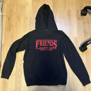 en svart hoodie med röd text ”friends dont lie”, från stranger things.