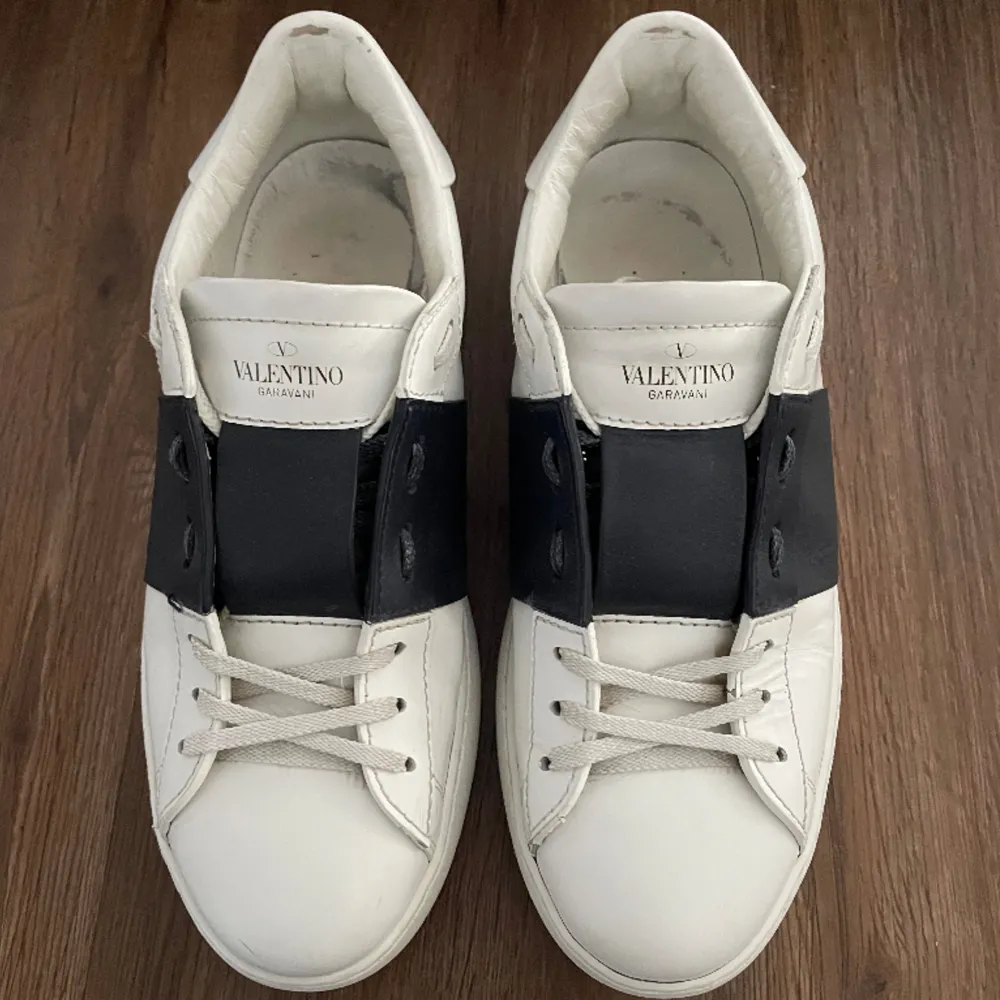 Valentino open sneakers med svart rand. Storlek 41 men skulle säga att de även passar om du har upp till 42. Fint skick, det finns tecken på användning på och i skon samt mindre creasing på båda skorna. Avgör skicket själv. Endast skorna följer med. Skor.