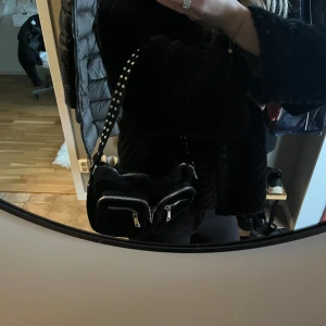 Noella väska - Superfin svart väska med silvriga detaljer från Noella. Den är sparsamt använd och i väldigt fint skick!💗🙌🏽 Medkommer även ett längre band till väskan. 