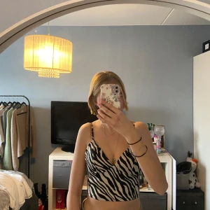 Topp i zebramönster  - En fin topp i zebramönster. Storlek M, men är liten i storleken. Är inte använd mer än 1 gång. 