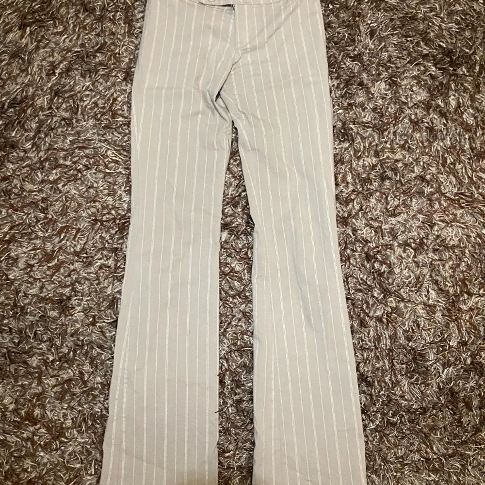 Beige utsvängda kostymbyxor med vita ränder.. Jeans & Byxor.