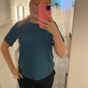 T shirt -  Tshirt från Weekday i en snygg grön-blå färg i bra kvalitet!