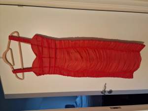 Knallrosa tajt klänning med mesh från Moochi Paris. Passar en 36. På bild syns jag, 178 cm lång, 59 kilo (stor 36a) och den var lite för tajt på mig. Använd en gång. Tjockt tyg, mkt stadga.