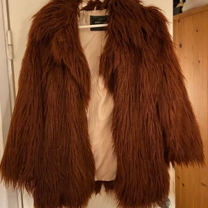 Fuskpälsjacka - En fin fuskpälsjacka i en brun/röd färg! Aldrig använd från river iland💗