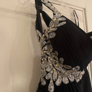 Balklänning med öppenrygg  - Svart balklänning i fint skick, endast använd 1 gång. Storlek 38. Slits och öppen rygg. 