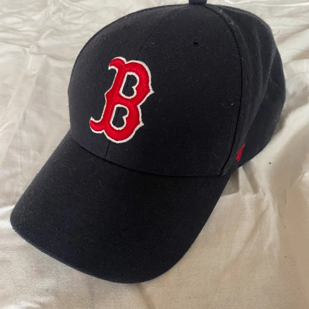 En marinblå baseboll keps, laget red sox. Kepsen är justerbar på baksidan och kepsen har inga slitage!. Accessoarer.