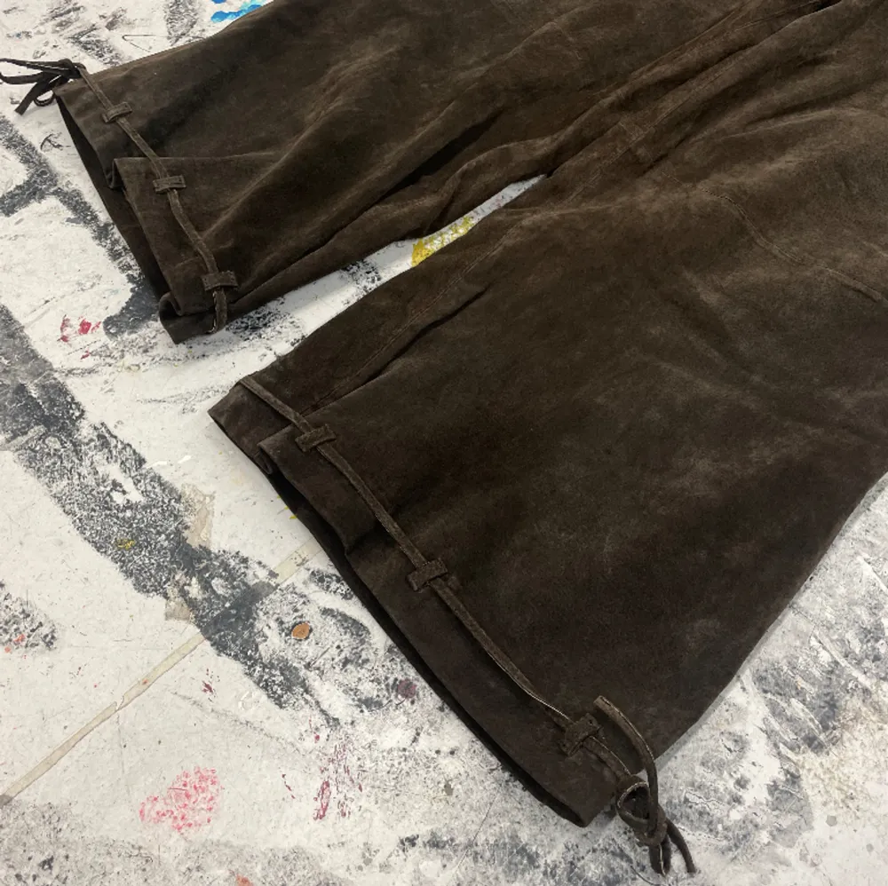 Unika vintage byxor med snörning både vid midjan och vid benöppningen. Materialet är läder/mocka. Midjemått 84cm, innerbenslängd 64cm.. Jeans & Byxor.
