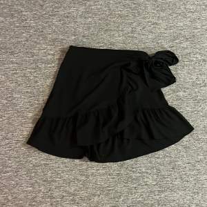 Fin begagnad kjol med knytning i sidan som fin detalj. Kommer från ett djur och rökfritt hem.