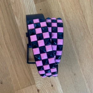 Rosa/svart nitbälte  - Använt en gång. Bältet är för stort för mig men det är jätte coolt🤑KÖPAREN STÅR FÖR FRAKT 