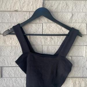 DIVIDED ribbad svart topp (S) - Svart ribbad croppad topp från H&M, storlek S. Säljer en i vit även så kika in den också 🤍 Använd endast ett fåtal gånger