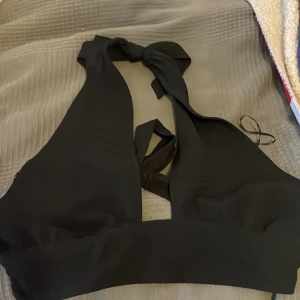 En svart topp - Säljer en svart sommartopp med knytning i ryggen och i nacken. Knappt använd🩷