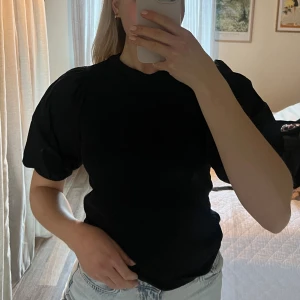 Svart topp  - Svart topp från Gina Tricot med puffärmar! 