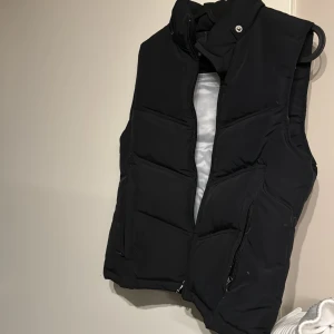 Väst - Svart väst som inte kom till användning  Fler bilder finns