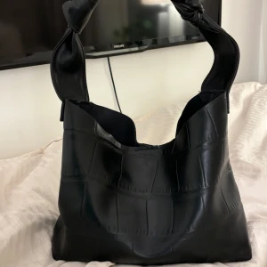 Väska - Säljer min fina väska då den aldrig kommit till användning. Nyskick och väldigt rymlig (mindre laptops och iPads får plats). Mjukt fake skinn material. 