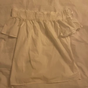 Vit topp  - En enkel men fin top till sommaren. Skön och luftig när det är varmt. Har en rak axel modell. 