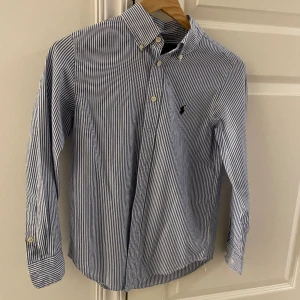 Ralph Lauren skjorta  - Hej, säljer nu denna snygga ralph lauren skjorta. Den är knappt använd och därefter i väldigt bra skick! Storlekarna är lite svåra på dessa men skulle säga att den passar bäst om man är runt 160-165 cm lång. Hör av er vid frågor. PRIS KAN DISKUTERAS