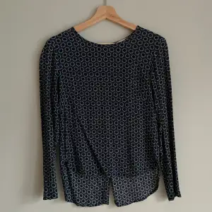 Säljer en blus med fint motiv som använts sparsamt! Blusen är mörkblå med mörkgröna ringar och har knäppning på baksidan (se bild).  