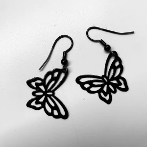 Svarta fjärilsörhängen - Svarta örhängen med söta fjärilar. Väldigt lätta så tynger inte ner örat :) fått dem av någon som ej gillade stilen längre. Sen kom de inte heller till användning hos mig. Pris kan självklart diskuteras!