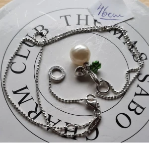 THOMAS SABO HALSBAND M BERLOCK.  - Thomas Sabo halskedja ca 46 cm lång som har en söt berlock qv en pärla m litet fyrklöver. Allt i fint begagnat skick.  Ask/påse ingår ej.  Kolla bilder o ställ ev frågor före bud.  Frakt tillkommer. 