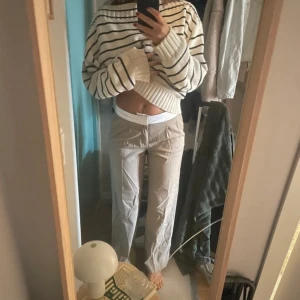 Beige byxor med vit bälte - Ett par beige byxor med vit bälte. Byxorna har en normal passform och är midwaist. aldrig kommit till användning 