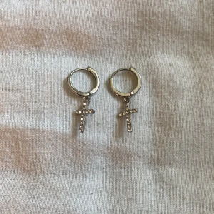 Fina örhängen  - Ett par jätte fina silvriga örhängen med ett kors på, dom är nästan aldrig använda och är i bra skick 