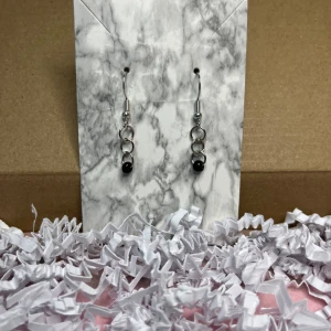 Svart örhänge  - Örhängen med svarta pärlor, ska vara i rostfritt stål.