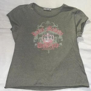 Olivgrön y2k tshirt med rhinestones  - Jättefin olivgrön tshirt med rosa detaljer och rhinestones. Några rhinestones saknas och det finns fläckar från blekningsmedel nära nacken (bild 2) men annars är den i bra skick. Skriv för fler bilder eller om du har frågor, använd gärna köp nu💕
