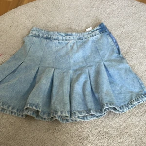 Jeanskjol - Jättesöt och trendig jeanskjol i ljusblå. Dragkedjan går inte att dra upp hela vägen som man ser på bilderna men kjolen sitter fast med en knapp på insidan också. Se sista bilden. 