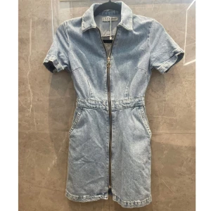 Jeansklänning - Blå jeansklänning med fickor. Storlek 32. Väldigt liten i storleken skulle jag säga. Bra skick