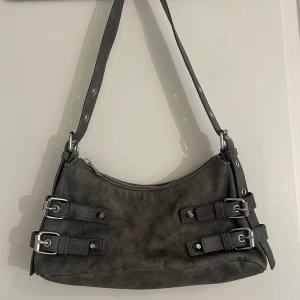 Grå väska - Säljer denna gråa axelväskan från Monki. Köpt på plick för ett tag sedan men kommer inte till användning. Väskan är i mycket fint skick och varsamt använd. Skriv för fler bilder eller funderingar :)