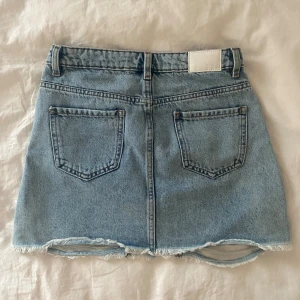 jeanskjol  - ljusblå jeanskjol med slitningar från mango i fint skick, går att välja lite hur man vill ha den men skulle säga att den är midwaist!