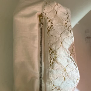 Vit necessär med spets - Vit necessär med spetsdetalj på ena sidan. 