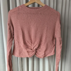 Stickad tröja - Stickad tröja med knytdetalj på magen. Använd men i bra skick. Storlek M men skulle mer säga att det är en S