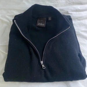 100% Cashmere halfzip Svart - Detta är en svart Halfzip från Oscar Jacobson i 100% Cashmere. Jag har använt den endast 2 gånger för några månader sedan. Sedan dess har den bara legat i garderoben. Den är i ett mycket bra skick och har absolut inga skador.