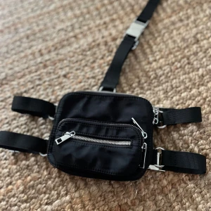 Magväska / festivalväska  - Går att justera på alla band. Även välja vilken sida man ska ha axelbandet. 3 st fack. Köpt från Dollskill USA. Helt ny! 