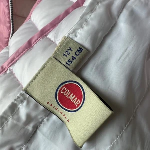 colmar väst - Ljusrosa Colmar väst, stl. 12Y/154cm (passar xs). Sparsamt använd men en lagad repa på vänster framsida (se bild). I övrigt bra skick. 