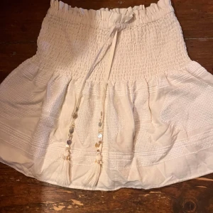 Kjol - Super söt kjol från zara endast använd några få gånger. Ny skick. Fina små snäckor nästan på snörena. 