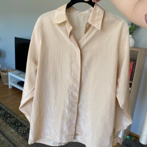 Skjorta - Randig skjorta i ljus peach färg. 